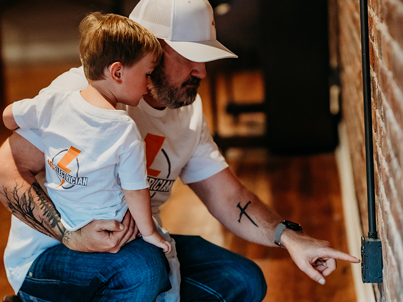 two generations working together in an electrician job